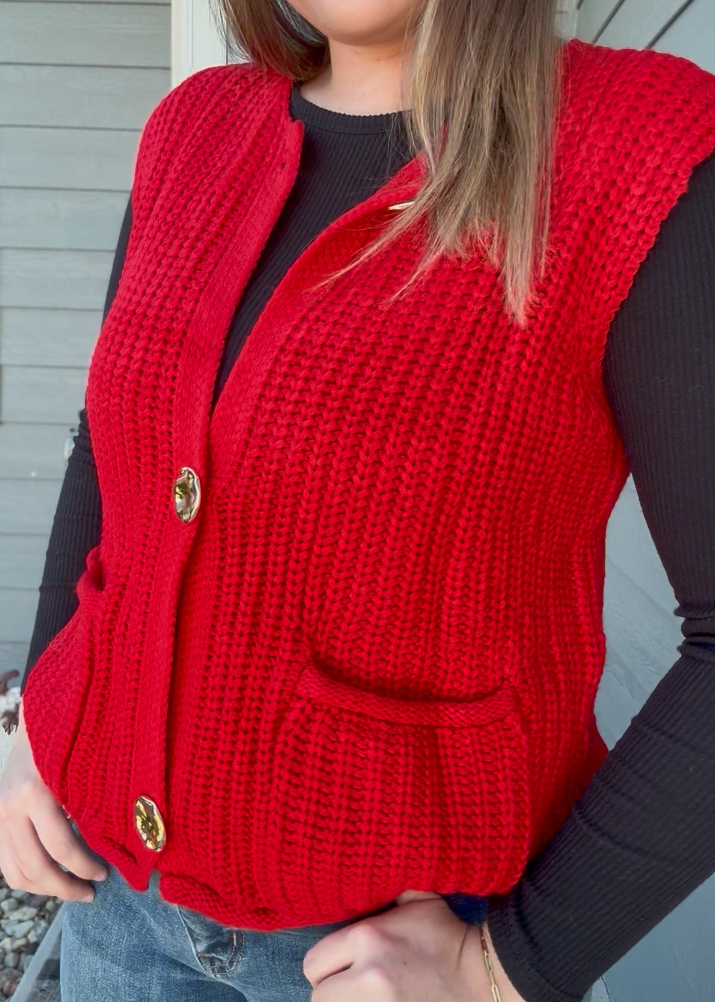 Red knitted vest worn by a person with a neutral background