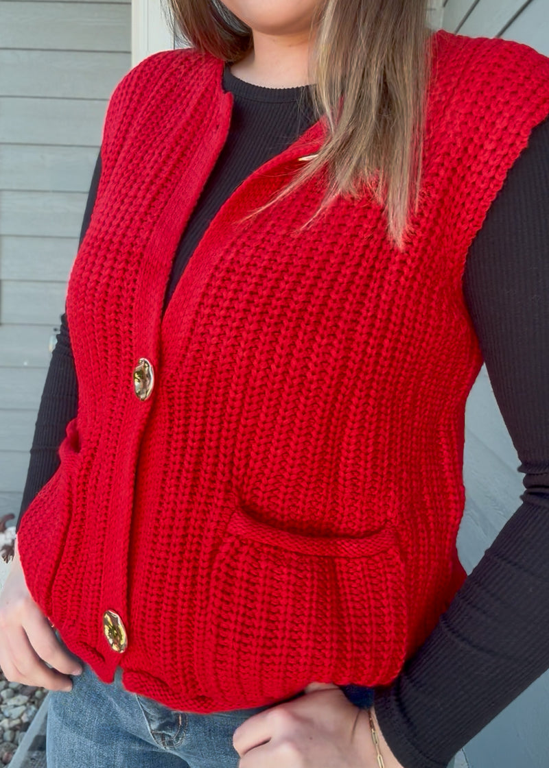 Red knitted vest worn by a person with a neutral background