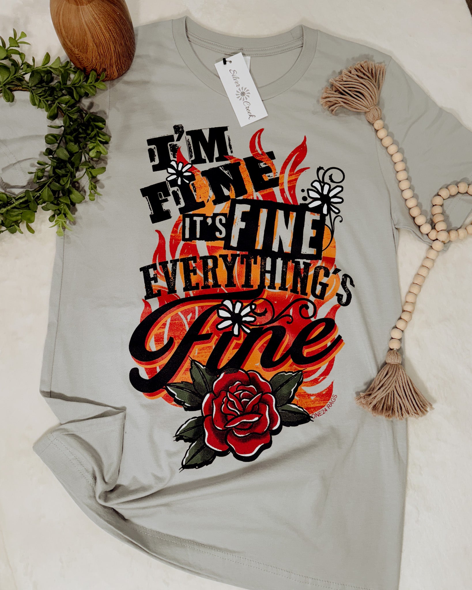 Gray t-shirt with colorful graphic design and text on a light background